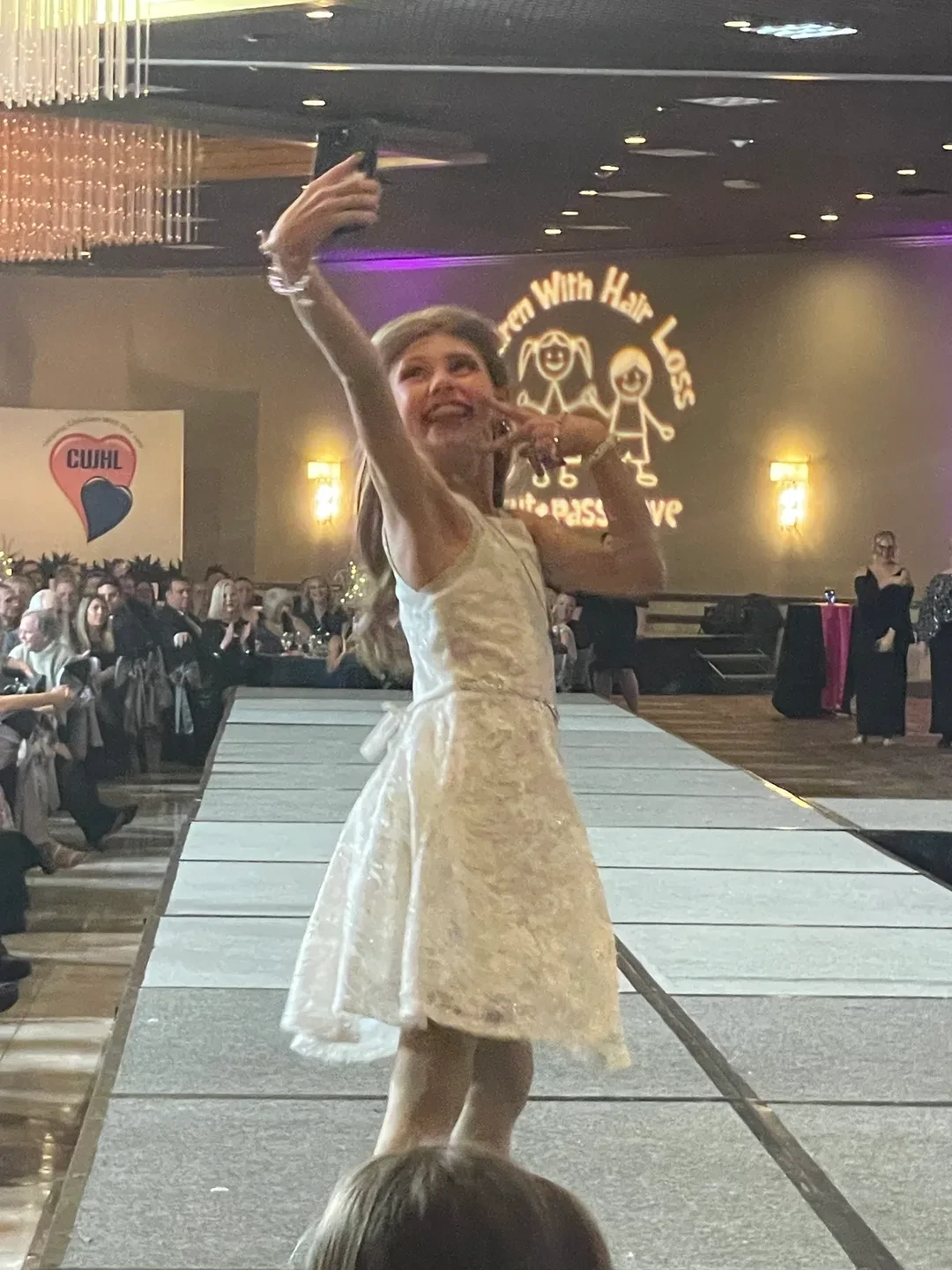Young girl walking the runway at the Children with Hair Loss Charity Ball